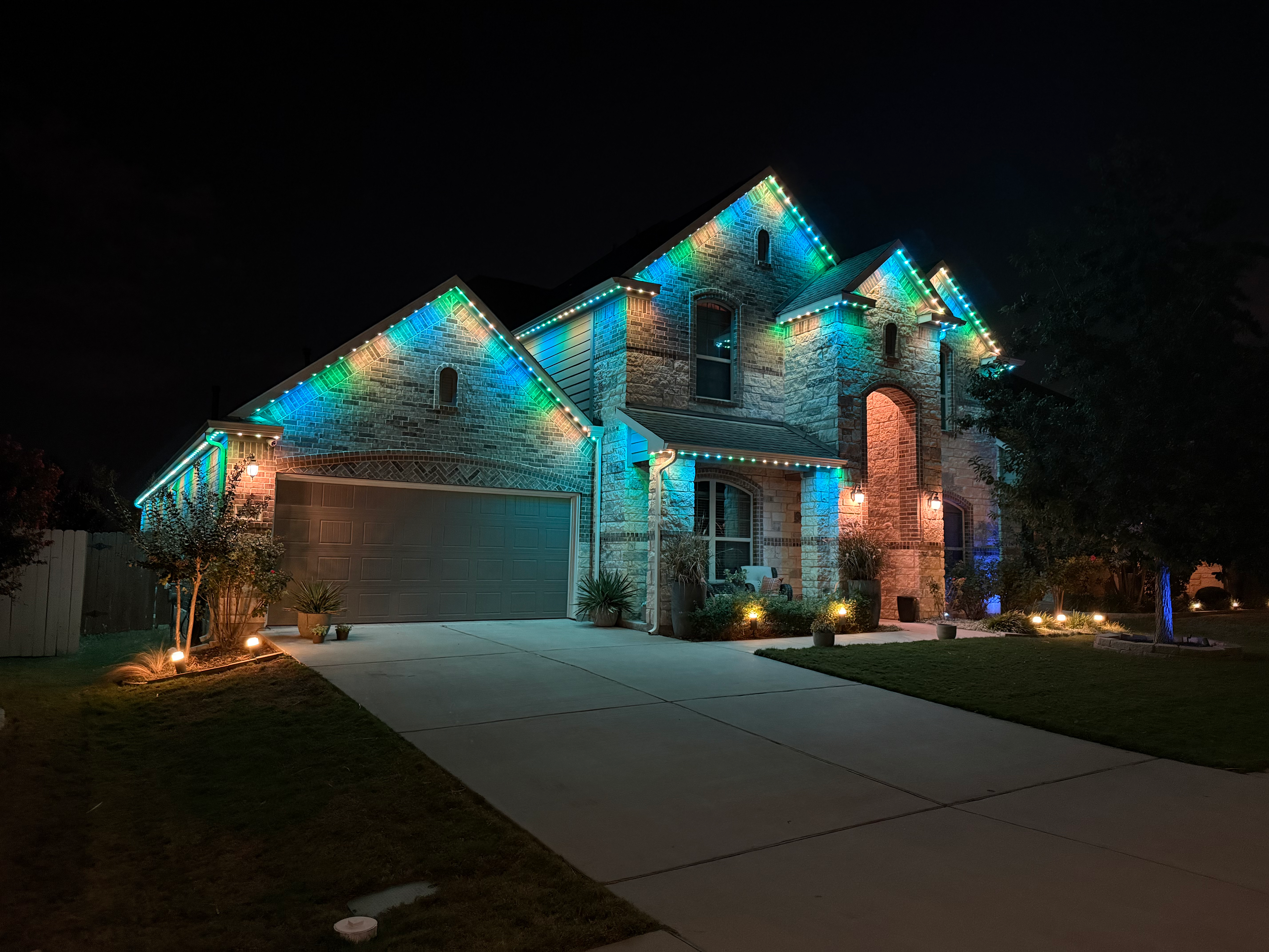 TruLight manufacturer example: Stone home lit with warm and cool white permanent lighting