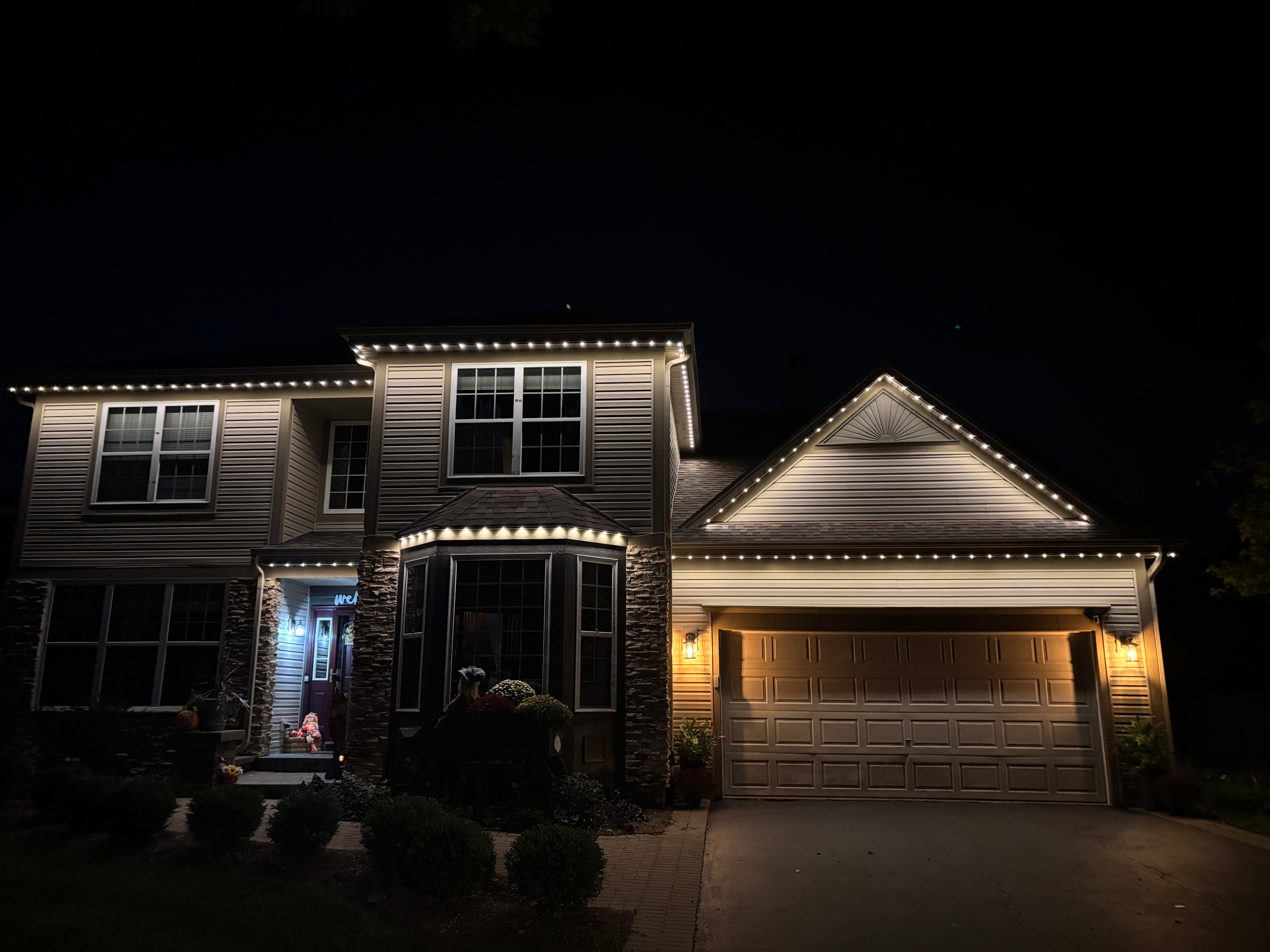 TruLight manufacturer example: Two-story home with white permanent roofline lighting